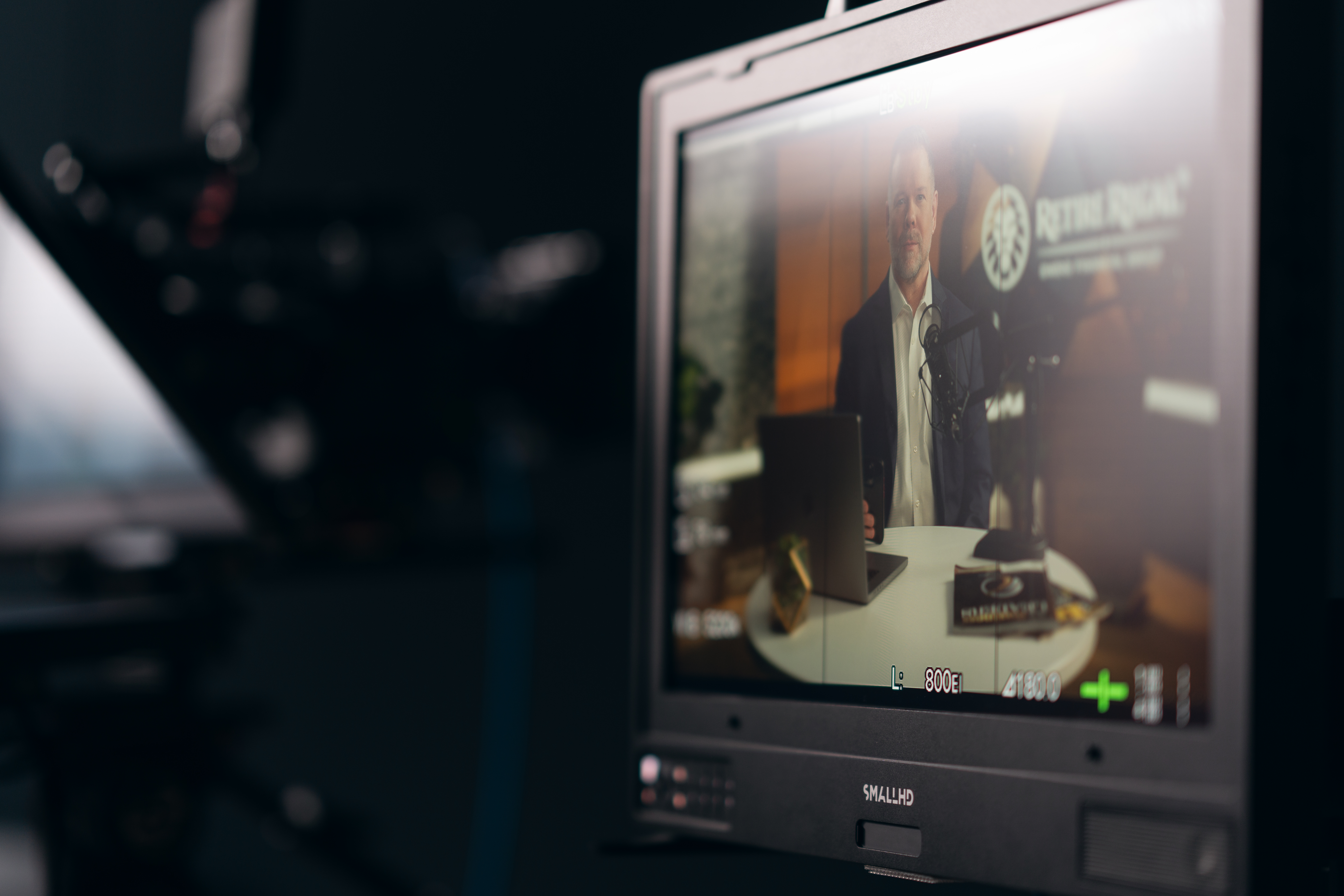 Chris Owens at Retire REGAL branded desk — between takes